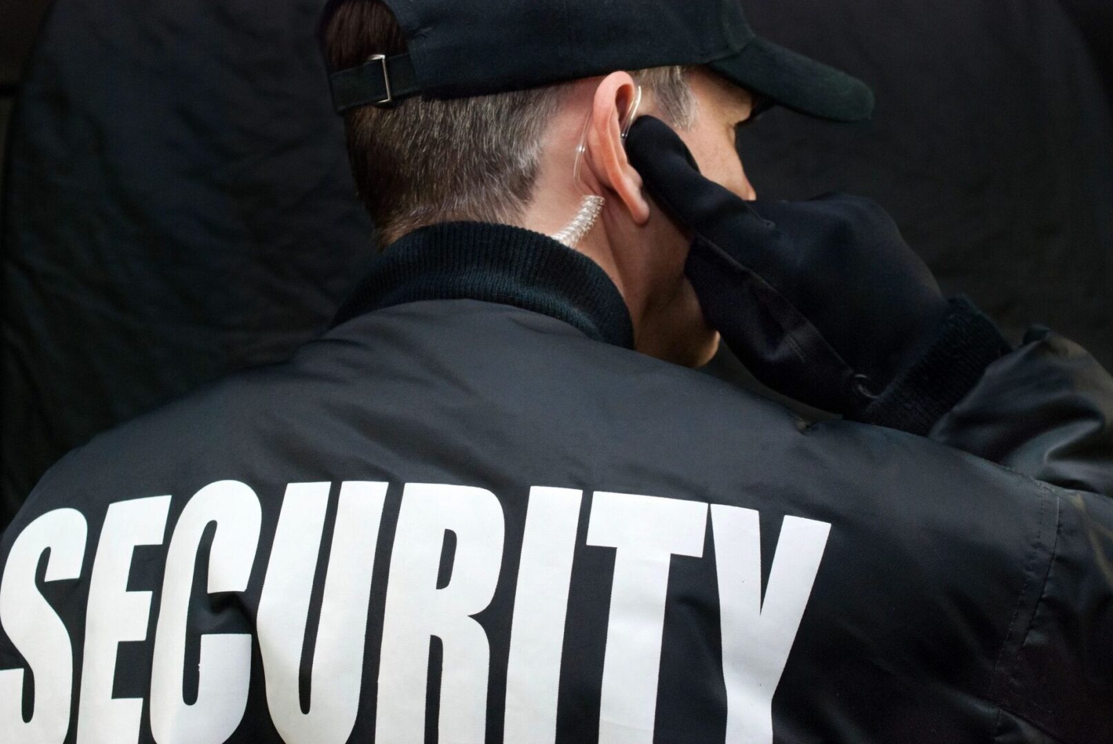 A security guard adjusts his ear plugs.